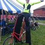 stilt walker on a bike, london