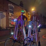 stiltwalkers on bikes with lights