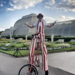 stilt walker on a bike at Kew gardens
